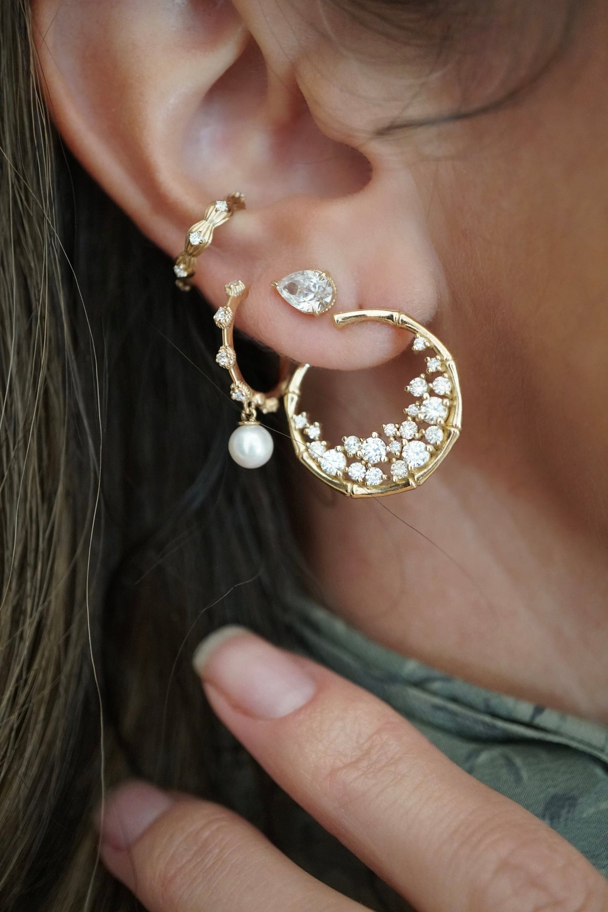 A close up shot of an ear, wearing the Diamond + Pearl Shell Hoops