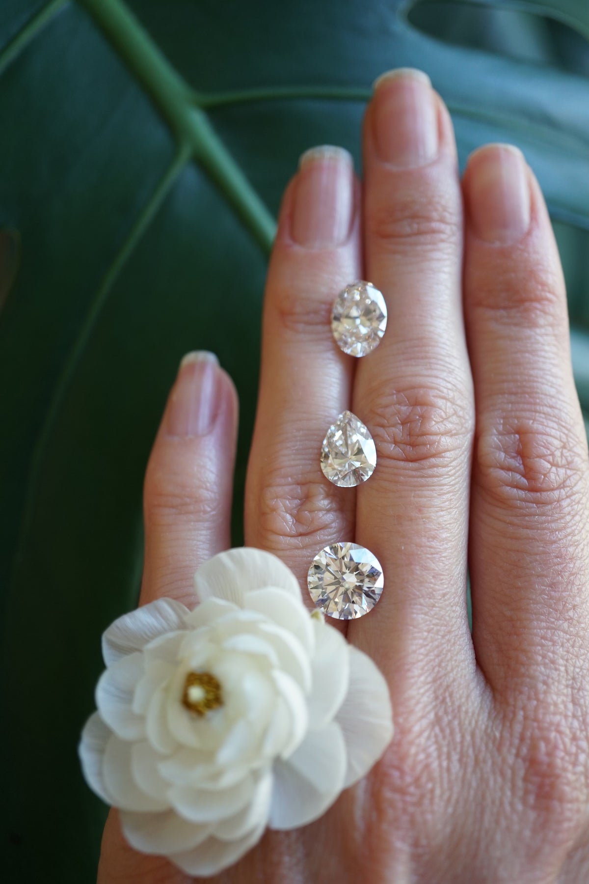 A flat back of the hand with three diamonds and a flower on it.