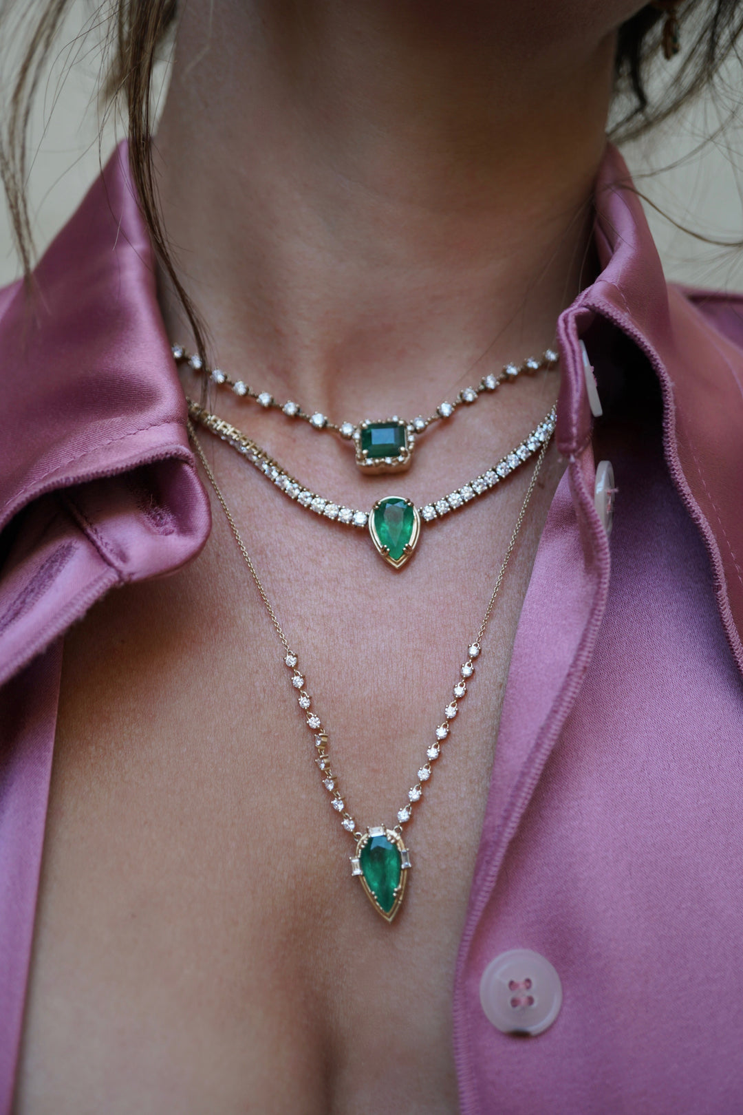 A close up shot of a woman wearing three necklaces from BaYou's collection.